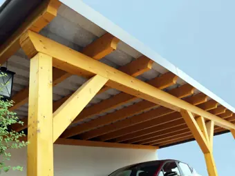 krásný dřevěno - plechový přístřešek na auto, kdy je pod ním už schované auto